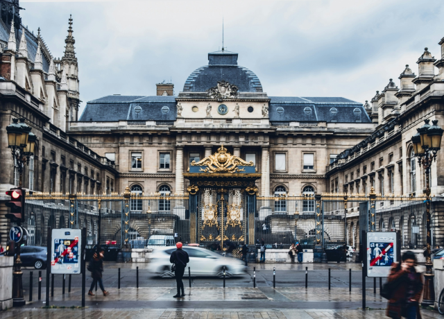 A large building in France featuring an ornate golden gate at the entrance, showcasing impressive architecture and design.